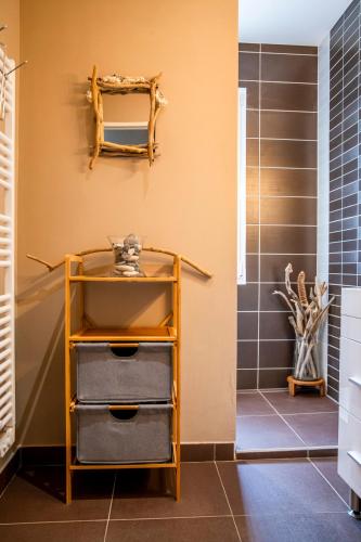 une salle de bain avec un mur jaune et une étagère dans l'établissement Evasion nature au val de l'Eyre, à Mios