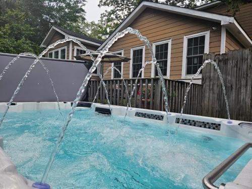 a pool with water shooting up into the air at Close to Downtown, 11-Person Swim Spa-Hot Tub, 75" TV 4 Movie Nights, Spacious, Walk To Restaurants, Ping Pong in Atlanta