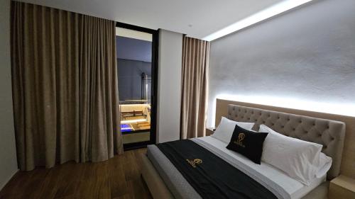 a bedroom with a bed with a large window at Aventus Luxury Villa in Rrushkull