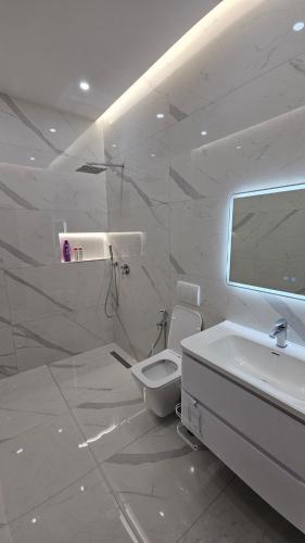 a white bathroom with a toilet and a sink at Aventus Luxury Villa in Rrushkull