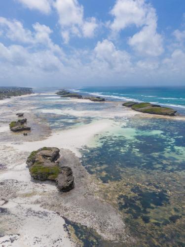 an aerial view of a beach with rocks and water at Serenity Penthouse Watamu in Watamu