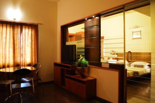 een hotelkamer met een televisie en een bed bij Malligi,Hampi in Hospet
