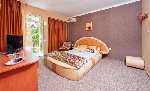 um quarto com uma cama grande e uma televisão em Peneka Hotel em Pomorie