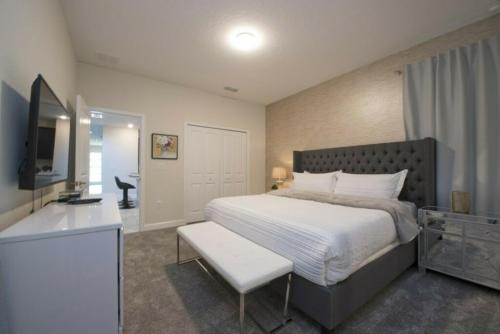 een slaapkamer met een groot bed en een televisie bij Modern Home with Private Pool and Game Room at Storey Lake SL2742 in Kissimmee