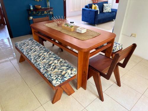 a wooden table with a bench and a table and chairs at Markinkia - Estancia Amazónica in Macas
