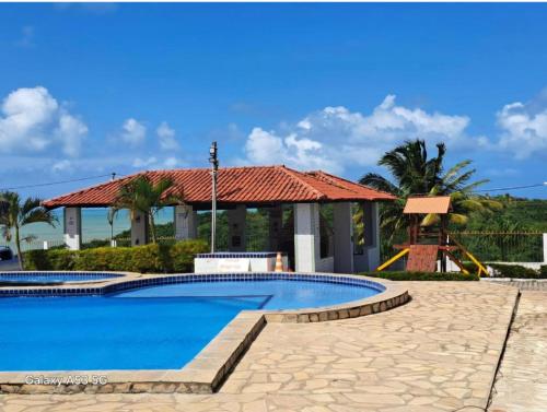 a swimming pool at a resort with a playground at Flat Mar doce lar in Conde