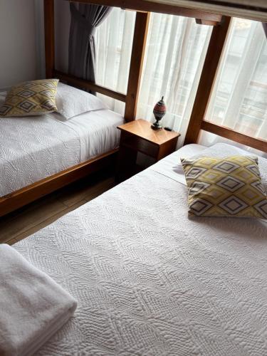 a bedroom with two beds and a window at Markinkia - Estancia Amazónica in Macas
