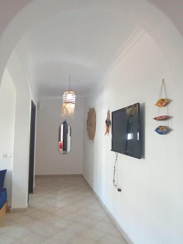 a living room with a tv on a white wall at Appartement à oued laou mekkad in Oued Laou