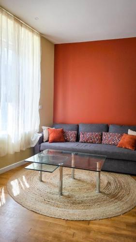 un salon avec un canapé et une table en verre dans l'établissement Le Terracotta, à Dieppe