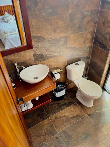 a bathroom with a white toilet and a sink at Markinkia - Estancia Amazónica in Macas