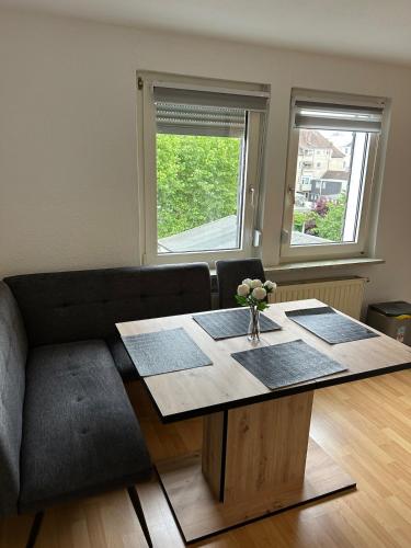 a living room with a table and a couch at Zentrales Apartment mit Netflix, Kaffee & Parkplätzen in Paderborn
