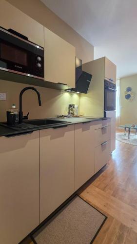 une cuisine avec des armoires blanches et un évier dans l'établissement Le Terracotta, à Dieppe