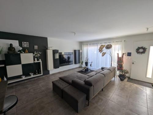 un salon avec un canapé et une télévision dans l'établissement La Maison du Soleil & du Calme Centre-ville à Pied Parking Privé à Nîmes !, à Nîmes