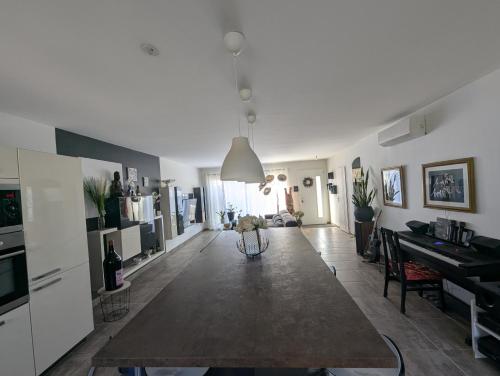 Il comprend un grand salon avec une table et une cuisine. dans l'établissement La Maison du Soleil & du Calme Centre-ville à Pied Parking Privé à Nîmes !, à Nîmes