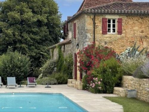 une maison avec une piscine devant une maison dans l'établissement Ferme Saint Martin le Redon, à Soturac
