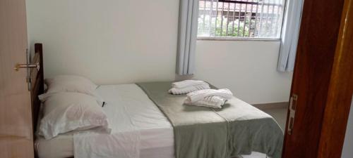 a bedroom with a bed with two towels on it at aeroporto e praia loft espaçoso in Vitória