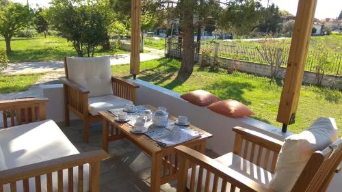 a patio with chairs and a table and a couch at Entire villa with big garden and BBQ amenities in Áyios Pávlos