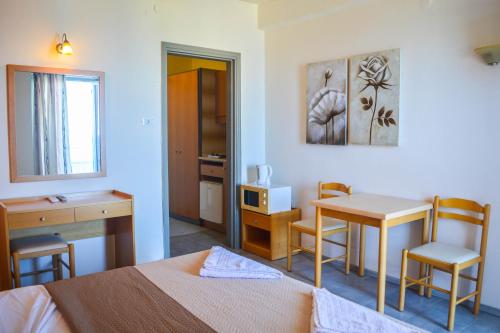 a bedroom with a bed and a desk and a table at Achillion Hotel in Rhodes Town