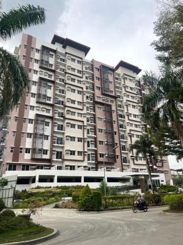 a large apartment building with a train in front of it at Matina Enclaves Bldg D 2Bedroom with balcony and view in Davao City