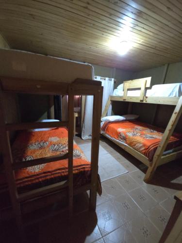 a room with two bunk beds in a cabin at La Casita De La Cueva in Cabo Rojo