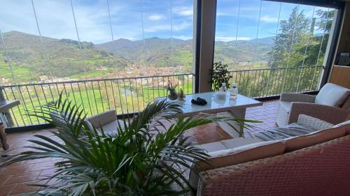 a balcony with a table and chairs and a view of mountains at Villa Casavecchia Caselli in Dicomano