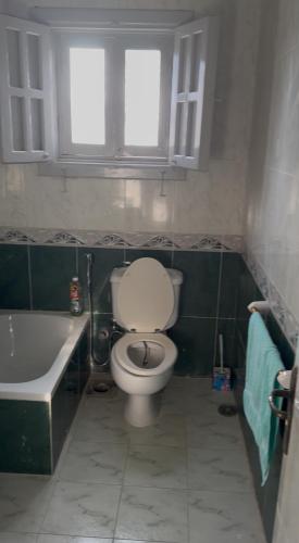 a bathroom with a toilet and a tub and a window at قريه سما العريش شاليه كامل 2 غرفه وصاله وتراس Sama ELARISH village in Maḥaṭṭet el- `Arîsh