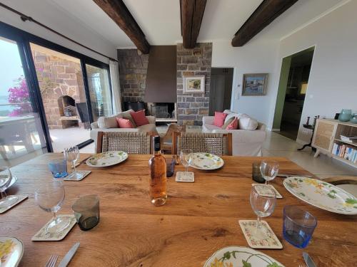 une table en bois avec des assiettes et des verres à vin dessus dans l'établissement Villa Vistaero, aux Issambres