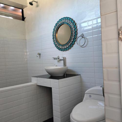 a bathroom with a sink and a toilet and a mirror at Tikary Lodge in Cusco