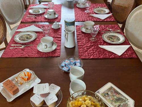 une table avec des assiettes et des bols de nourriture dans l'établissement Évasion Naturelle: Chambre d'Hôtes Spacieuse avec Piscine et Confort à Montreuil-le-Henri - FR-1-410-446, à Montreuil-le-Henri