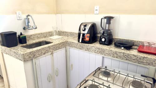 a kitchen counter with a sink and a blender at Casa Aconchegante Sete Lagoas - 35A in Sete Lagoas