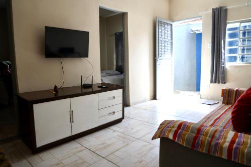 a living room with a flat screen tv on the wall at Casa Aconchegante Sete Lagoas - 35A in Sete Lagoas