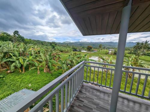 a balcony of a house with a view of a field at Nature Retreat Mantayupan Waterfalls in Barili