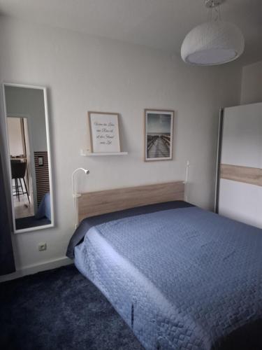 ein weißes Schlafzimmer mit Bett und Spiegel in der Unterkunft ZWEITE REIHE FLAIR Ferienwohnungen in Krakow am See