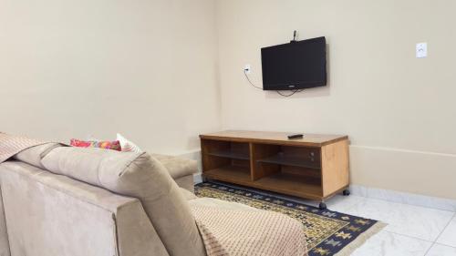 a living room with a couch and a tv at Casa 3Km do centro Sete Lagoas - 35 in Sete Lagoas