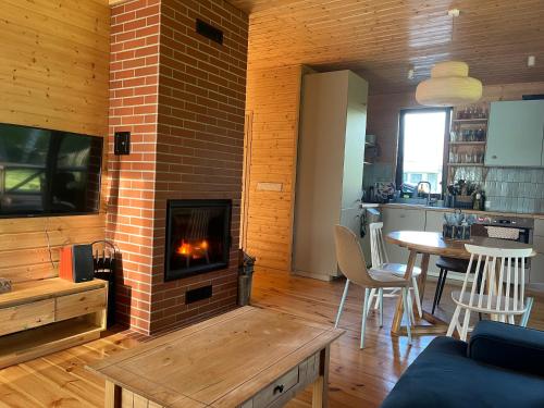 a living room with a brick fireplace and a table at Dom na Perłowej in Kopalino