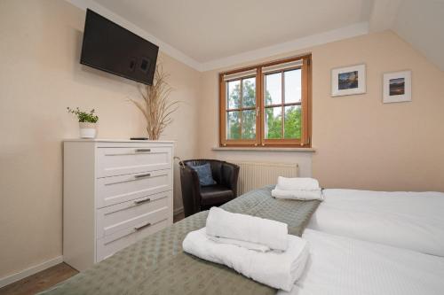 a bedroom with two beds and a dresser and a chair at Ferienwohnung-Am-Hoepen in Rechlin