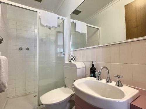 a bathroom with a sink and a toilet and a shower at High Plains Lodge Rooms in Dinner Plain