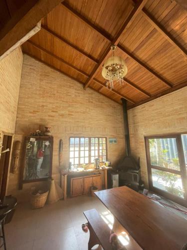 a living room with a wooden ceiling and a table at InnFloripa - Pousada no Campeche 7 min do Aeroporto in Florianópolis
