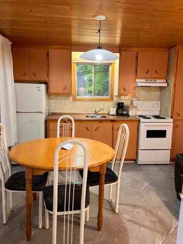 a kitchen with a wooden table and chairs and a sink at Camping Chalets Lac St-Augustin in Quebec City