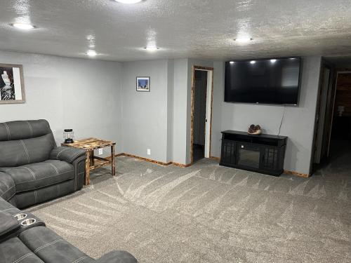 a living room with a couch and a flat screen tv at Cozy Home Between Zion & Bryce in Kanab