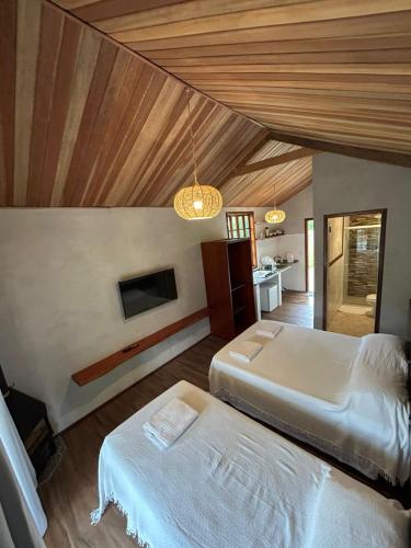 two beds in a room with wooden ceilings at Centro de Lazer Pingo d'água in Caxambu