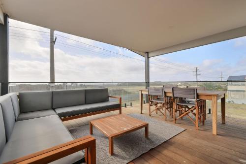 a living room with a couch and a table and chairs at Surf Mist at Surf Beach in Surf Beach