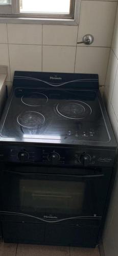 una stufa nera in una cucina con una finestra di Departamentos frente Andrey si mascotas a Mar del Plata