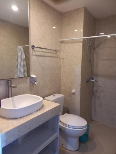 a bathroom with a sink and a toilet and a shower at PENTAPOLIS WONGKITO APARTMENT di pusat kota Balikpapan in Stalkudo