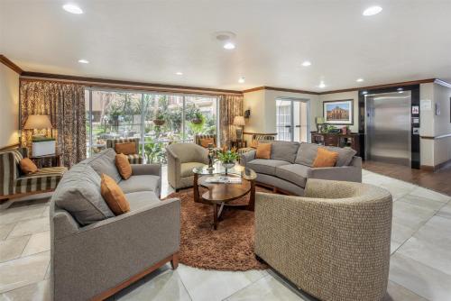 a living room with two couches and a table at Best Western Plus Atrium Inn in Schertz