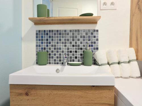 La salle de bains est pourvue d'un lavabo blanc et d'un mur carrelé bleu. dans l'établissement Holiday Home in Gargas with Pool and Nature, cleaning included, à Gargas