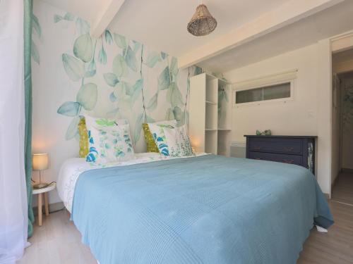 - une chambre avec un lit bleu et un mur fleuri dans l'établissement Holiday Home in Gargas with Pool and Nature, cleaning included, à Gargas