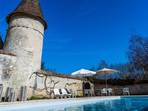 - une piscine avec des chaises et des parasols à côté d'un bâtiment dans l'établissement Castle in le Veurdre near Route Compostella, cleaning included, à Le Veurdre