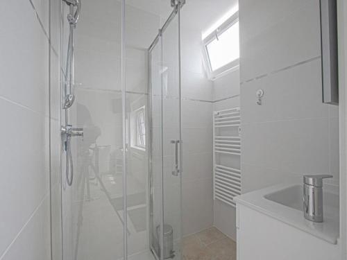 une salle de bain blanche avec une douche et un lavabo dans l'établissement Holiday Home in Isigny-sur-Mer with Garden, cleaning included, à Isigny-sur-Mer