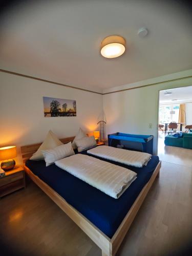 a bedroom with a large bed with a blue blanket at Ferienwohnung Bad Saarow "Am Märkischen Meer" in Bad Saarow